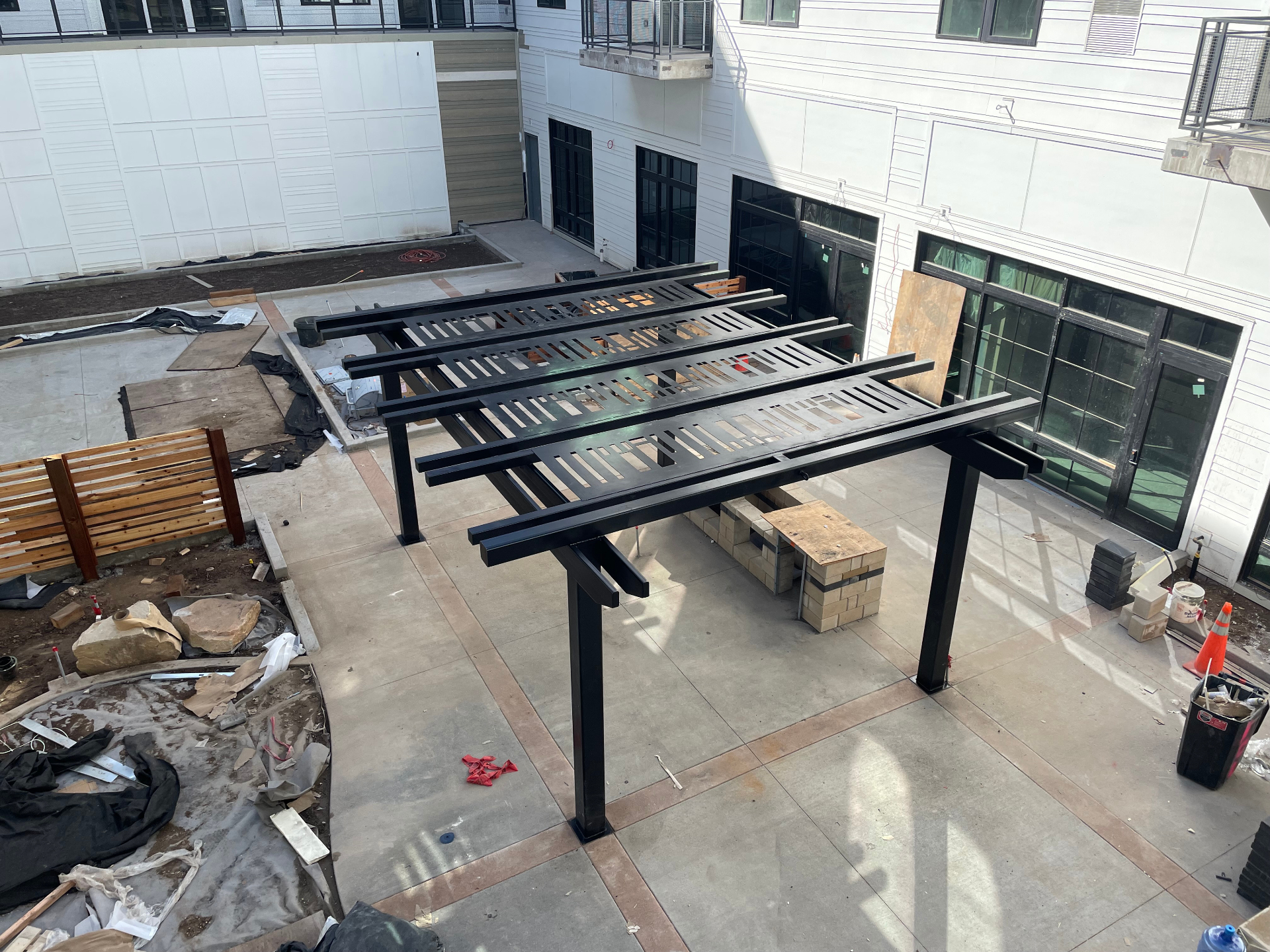 Blackened steel pergola structure in a courtyard installation