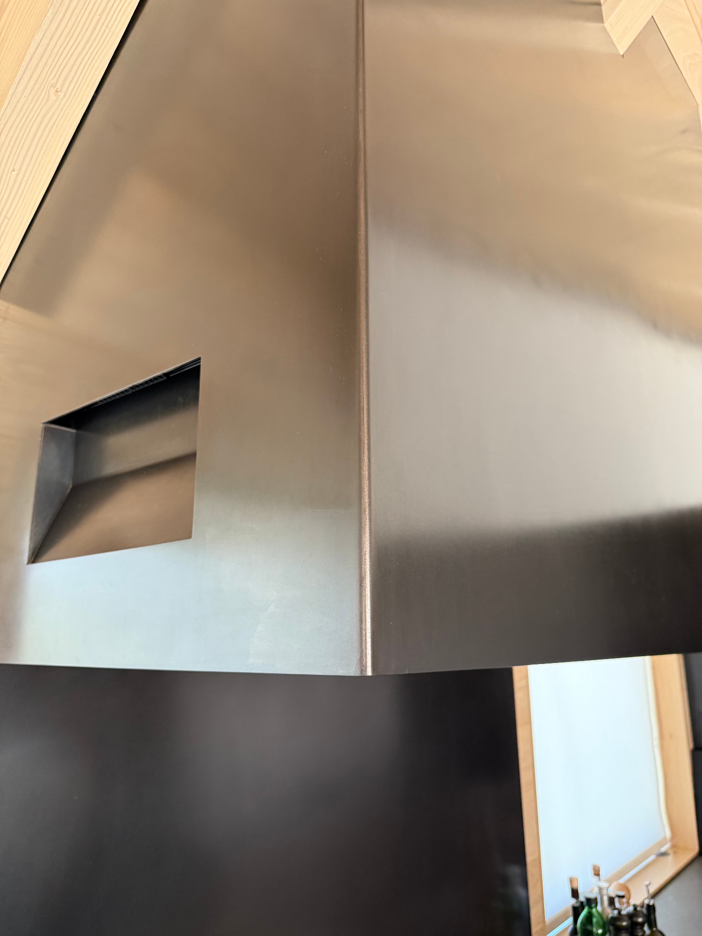 Blackened stainless kitchen hood seam detail